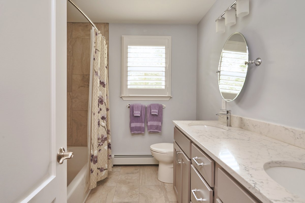 Compact hall bathroom by Lang's Kitchen & Bath with an alcove tub, toilet, and vanity along one wall
