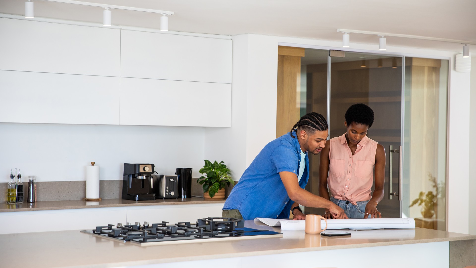 Recent homebuyer couple reviewing a kitchen renovation plan with a designer at a Bucks County showroom
