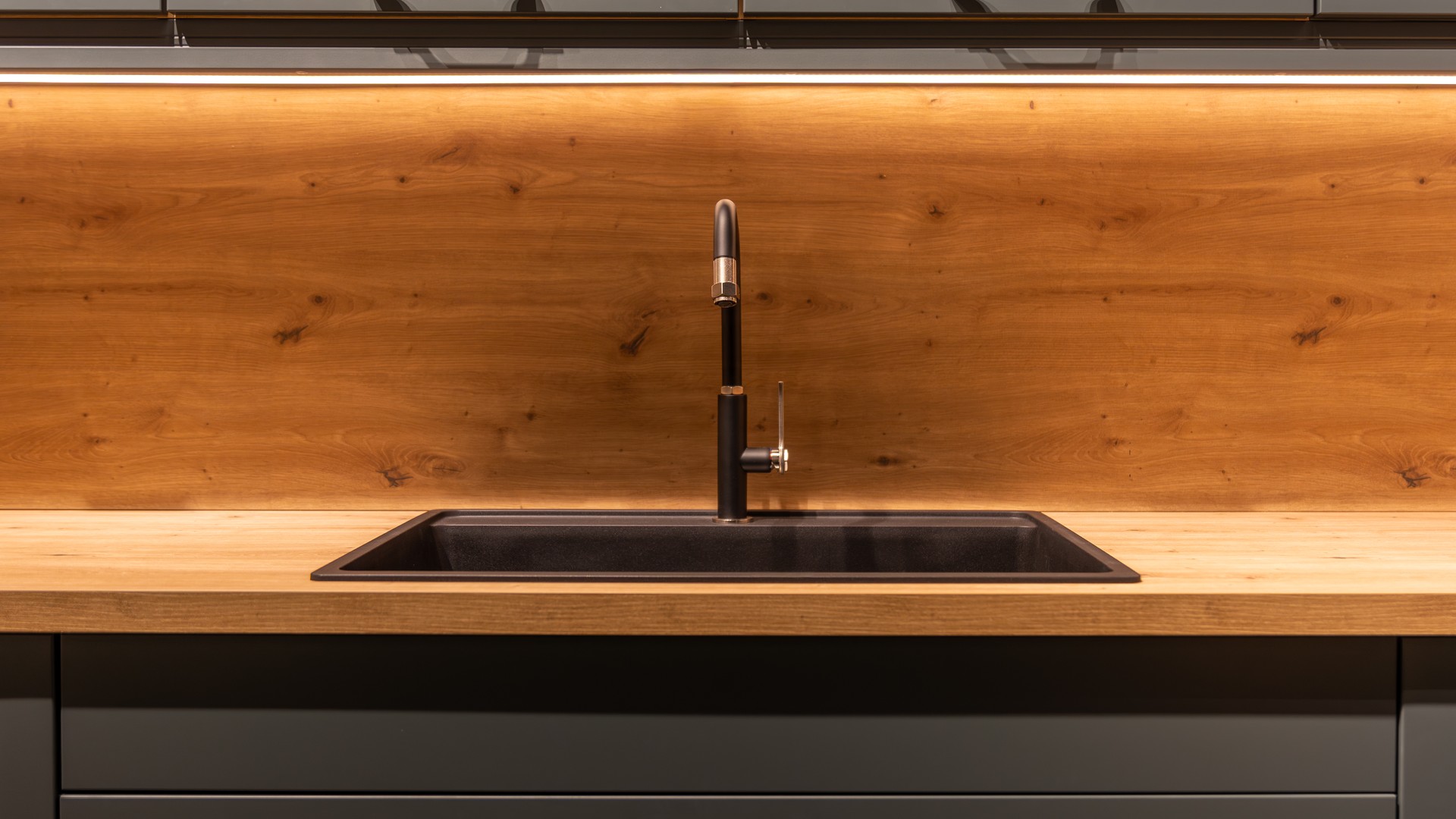 Installer sealing the sink cutout of a maple butcher block countertop in a kitchen
